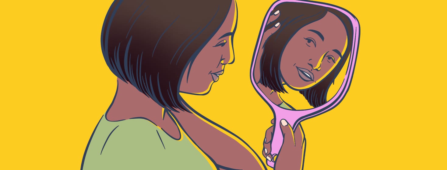 A woman admires her reflection in a handheld mirror