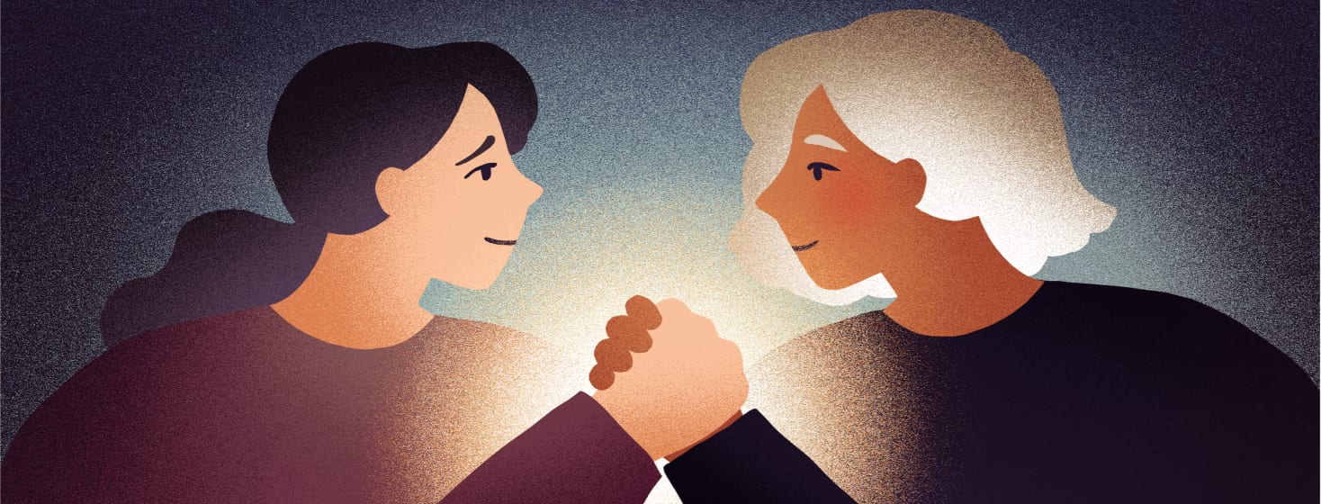 Two women hold hands in a show of support.